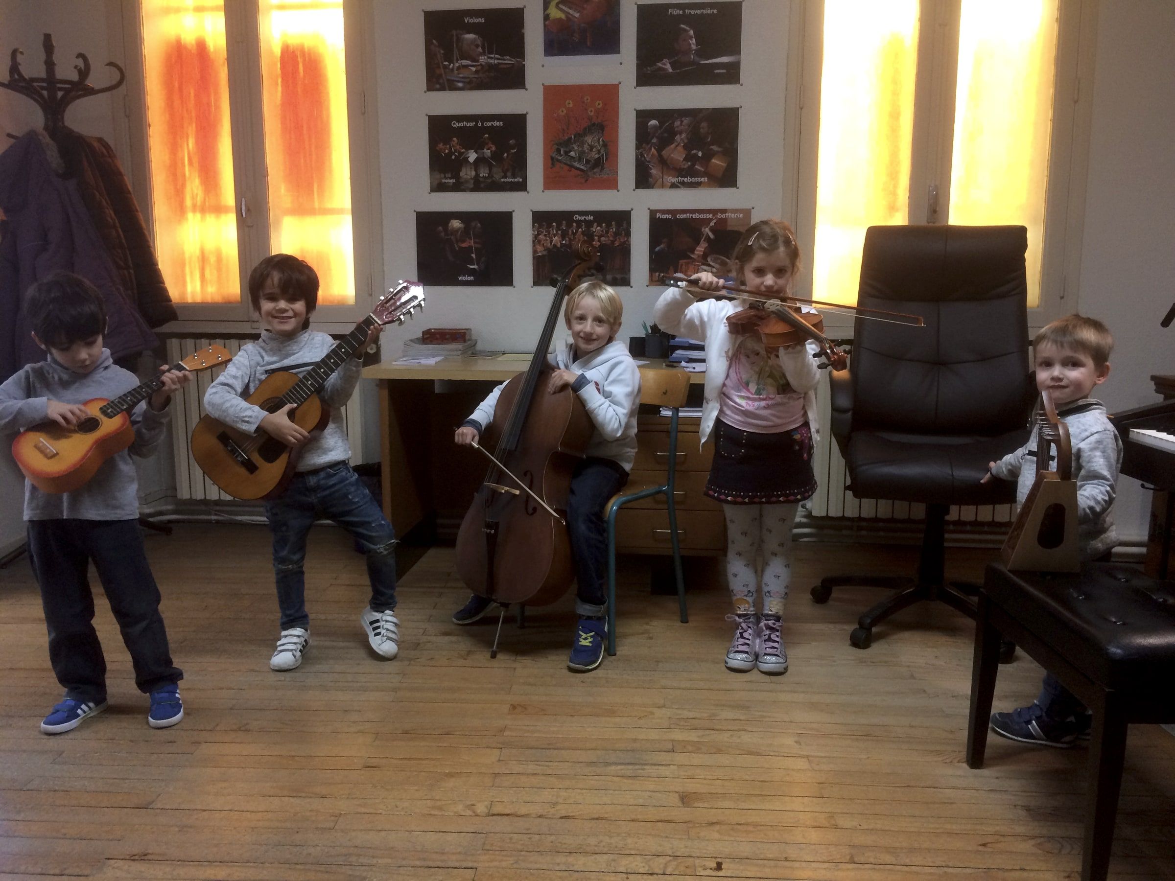 Cinq enfants avec guitares, violoncelle et violon