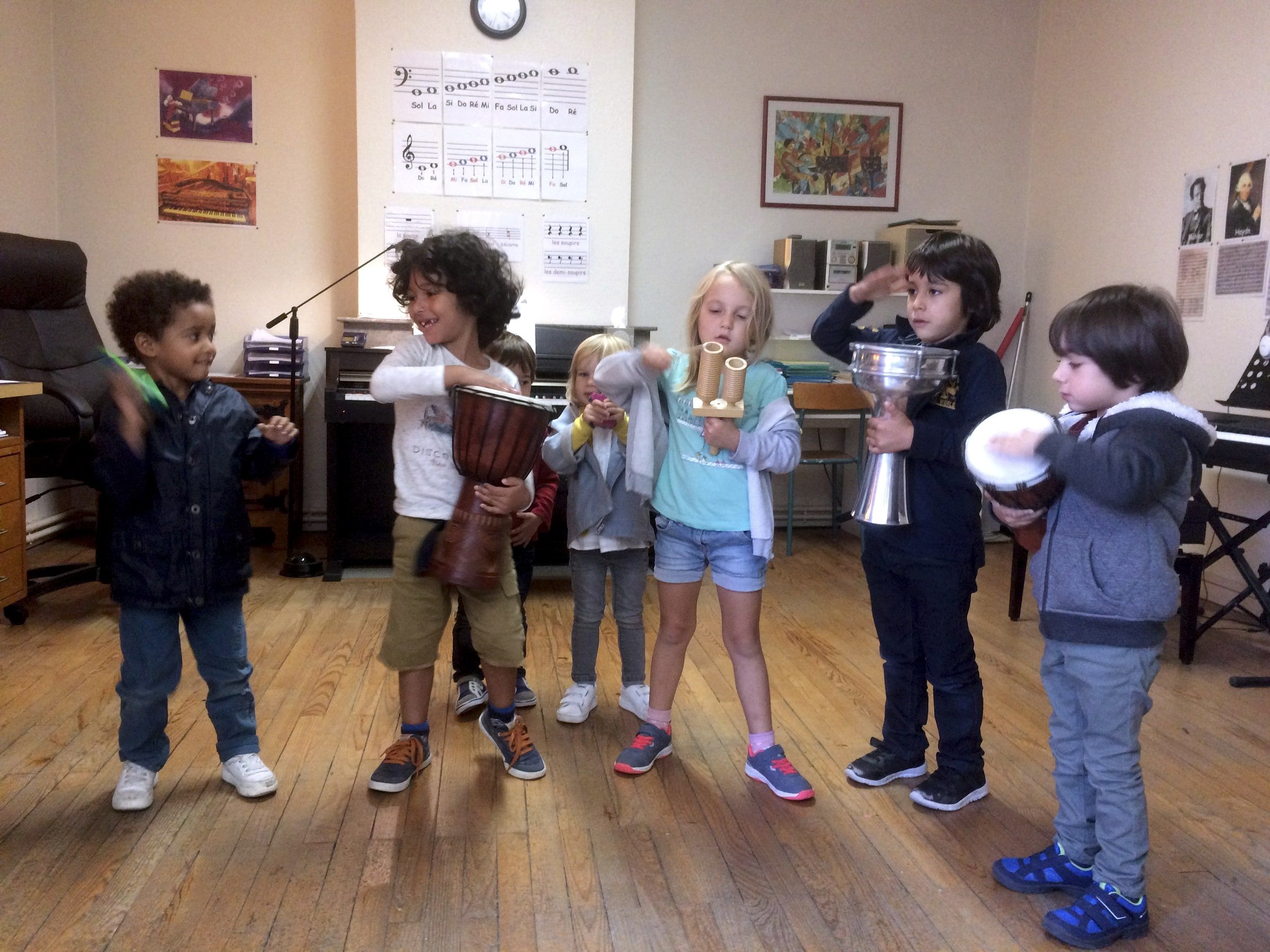 Enfants debout jouant du djembé et d'autres percussions