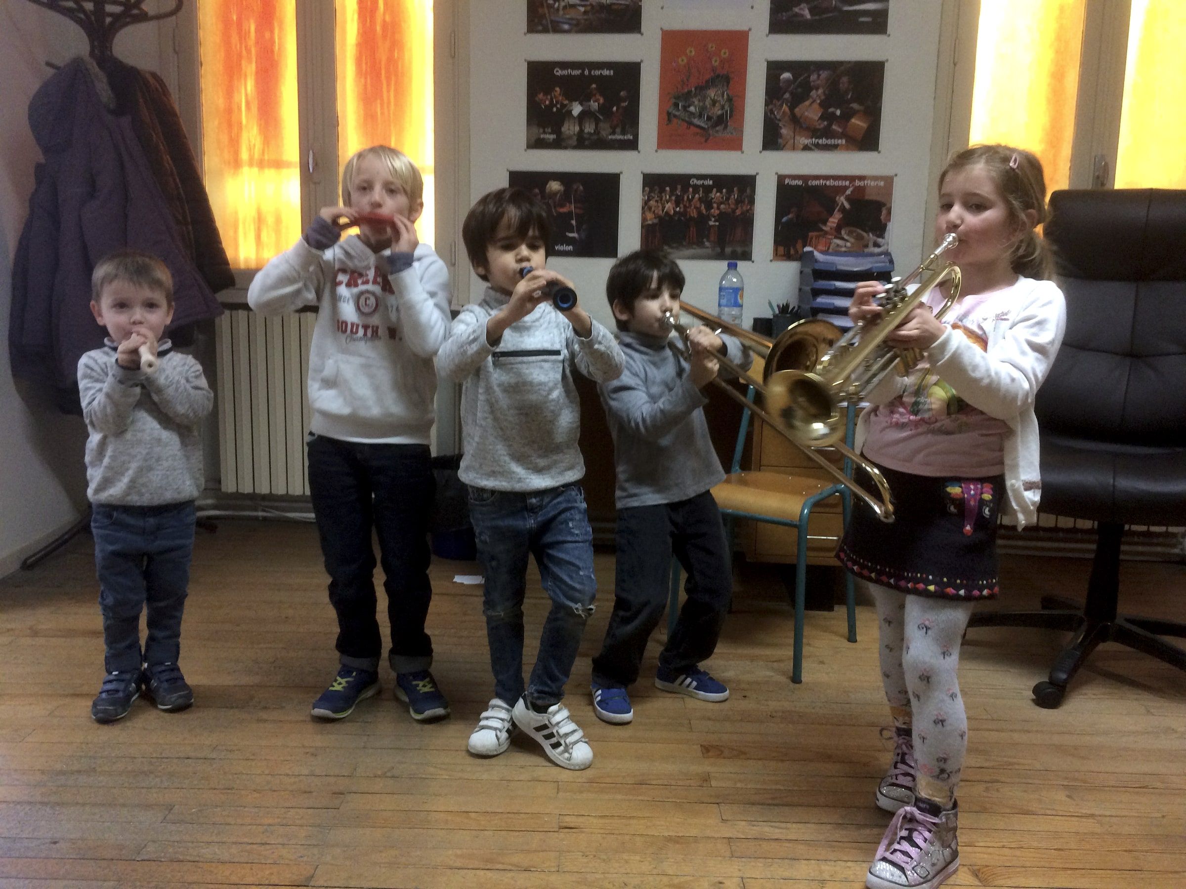 Enfants soufflant dans des flûtes, un trombone et une trompette